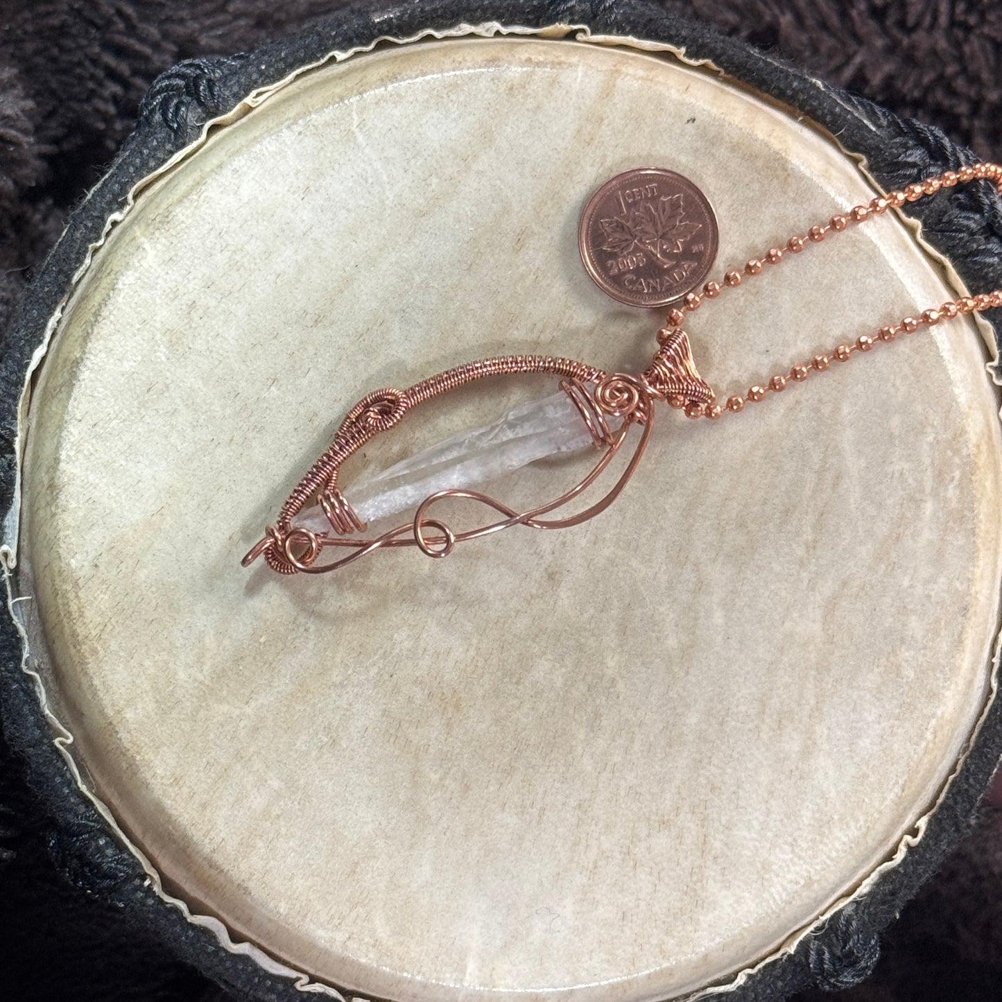 Alternate angled view of an open-work Lemurian quartz necklace with raw copper spirals, woven bail and 21-inch faceted ball chain.
