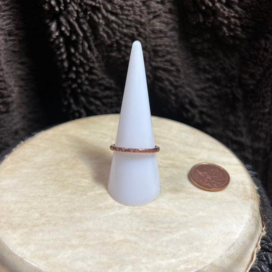 White cone-shaped object with a copper ring on a textured surface