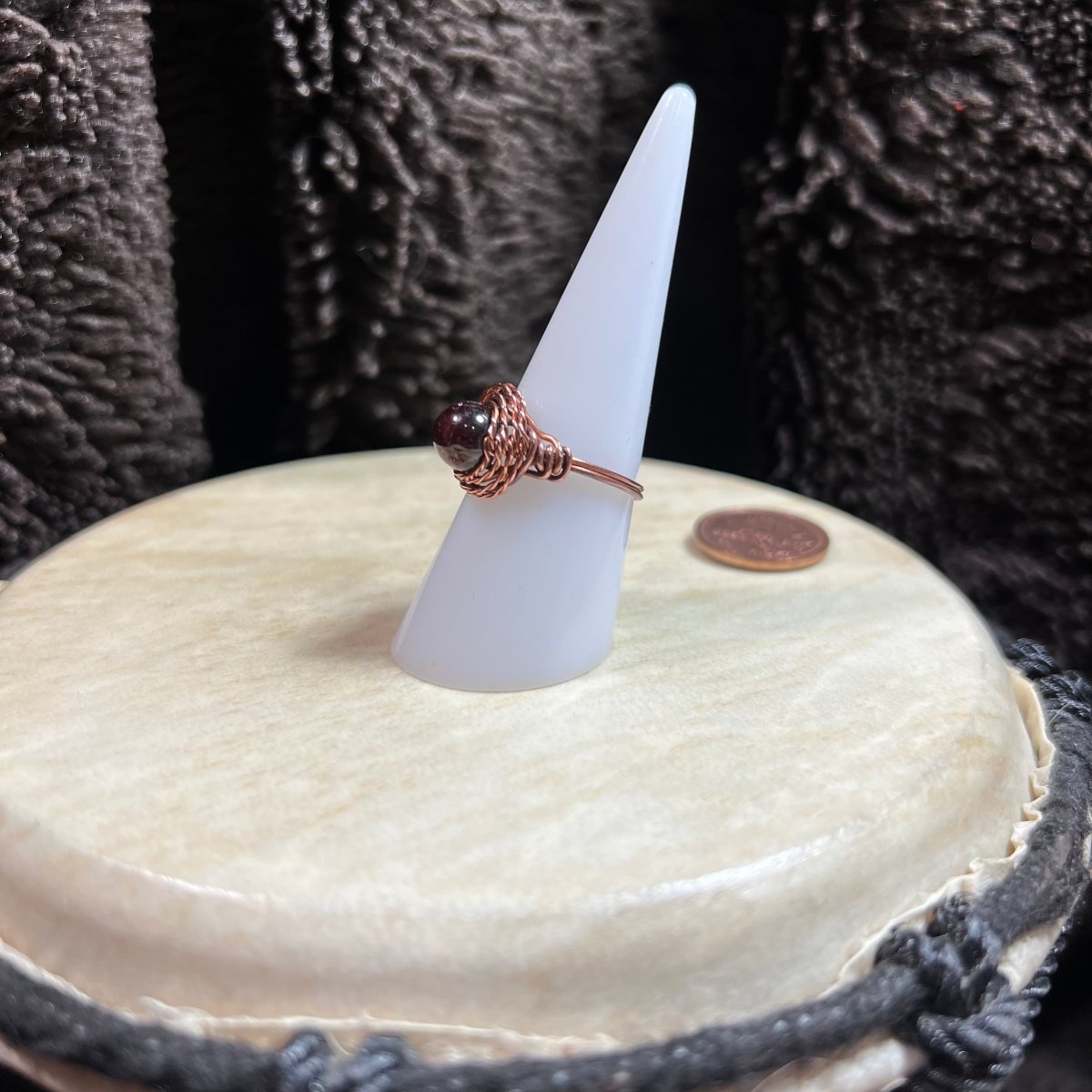 Ring on a white cone-shaped stand with a textured surface background