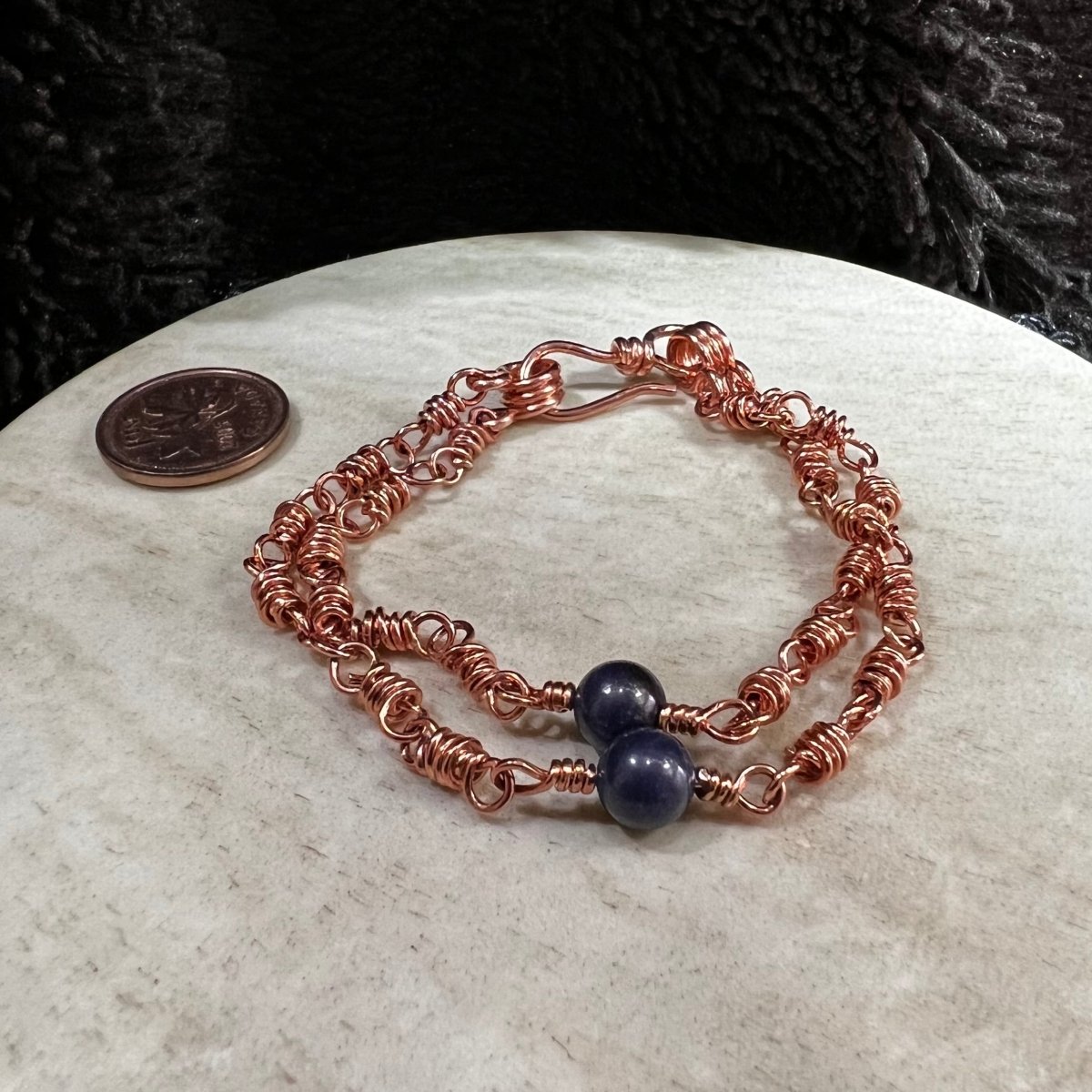 sodalite double strand bracelet with 6mm blue beads and reclaimed copper wire links, handmade calming clarity bracelet on neutral background next to a Canadian penny for scale