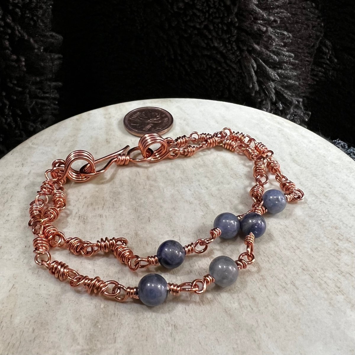 sodalite double strand bracelet with reclaimed copper wire links and 3 blue stone beads per strand, handmade calming crystal bracelet on neutral background