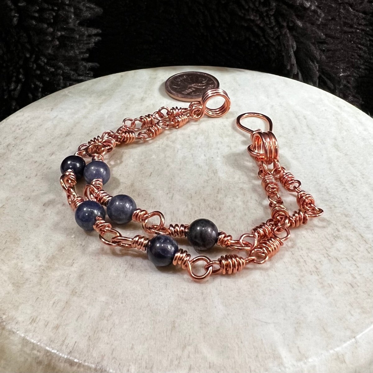 sodalite double strand bracelet with three 6mm blue beads per strand and reclaimed copper wire links, handmade asymmetrical clarity bracelet on neutral background