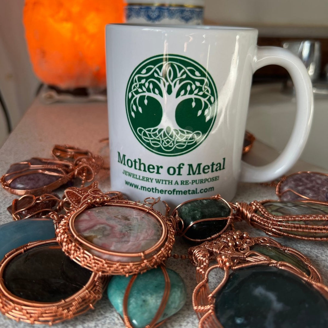 branded coffee cup surrounded by wire wrapped jewellery pieces