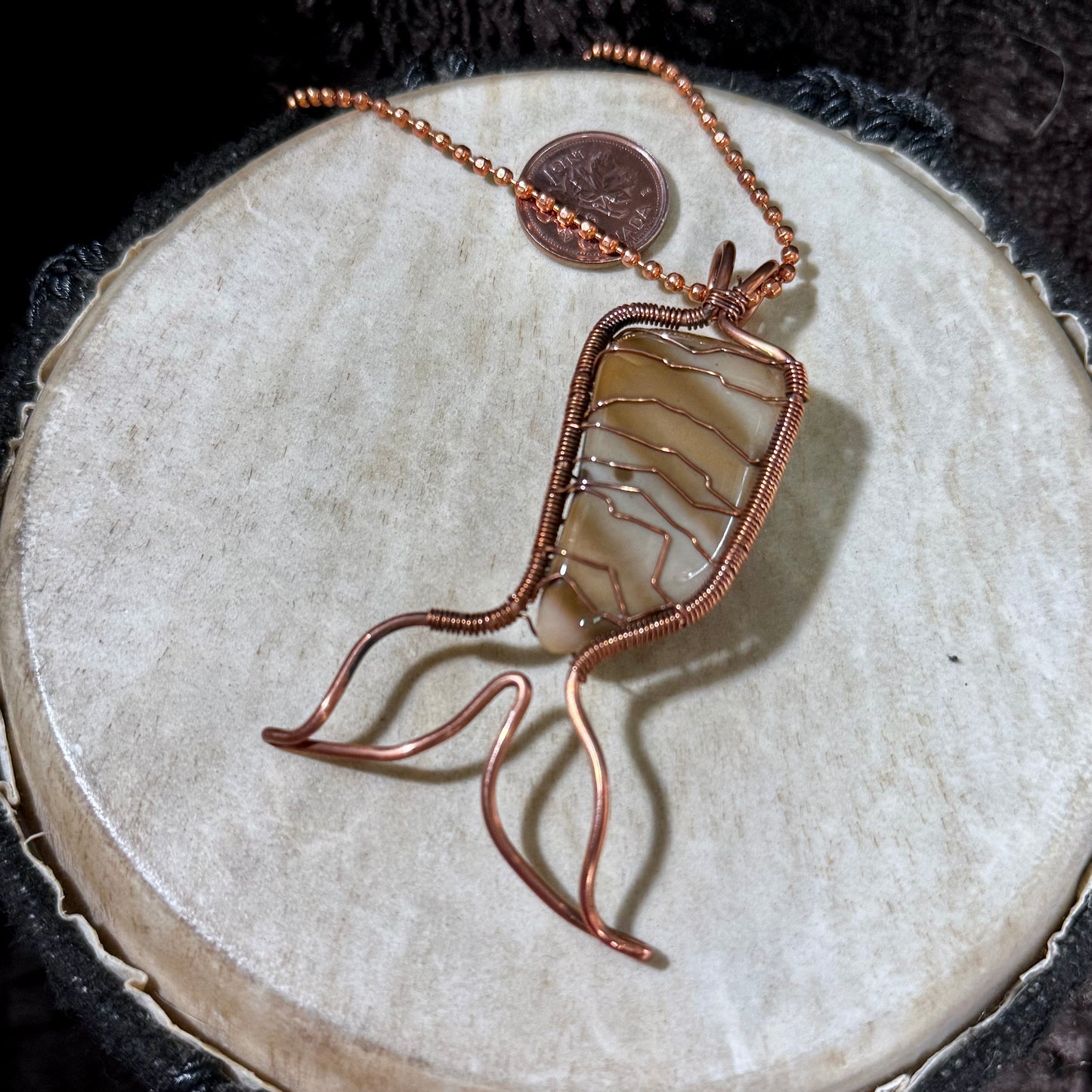 Handmade Bay of Fundy Jasper Mermaid Tail pendant wrapped in reclaimed copper. This one-of-a-kind artisan necklace features warm cream and brown banding inspired by the natural beauty of New Brunswick's Bay of Fundy.
