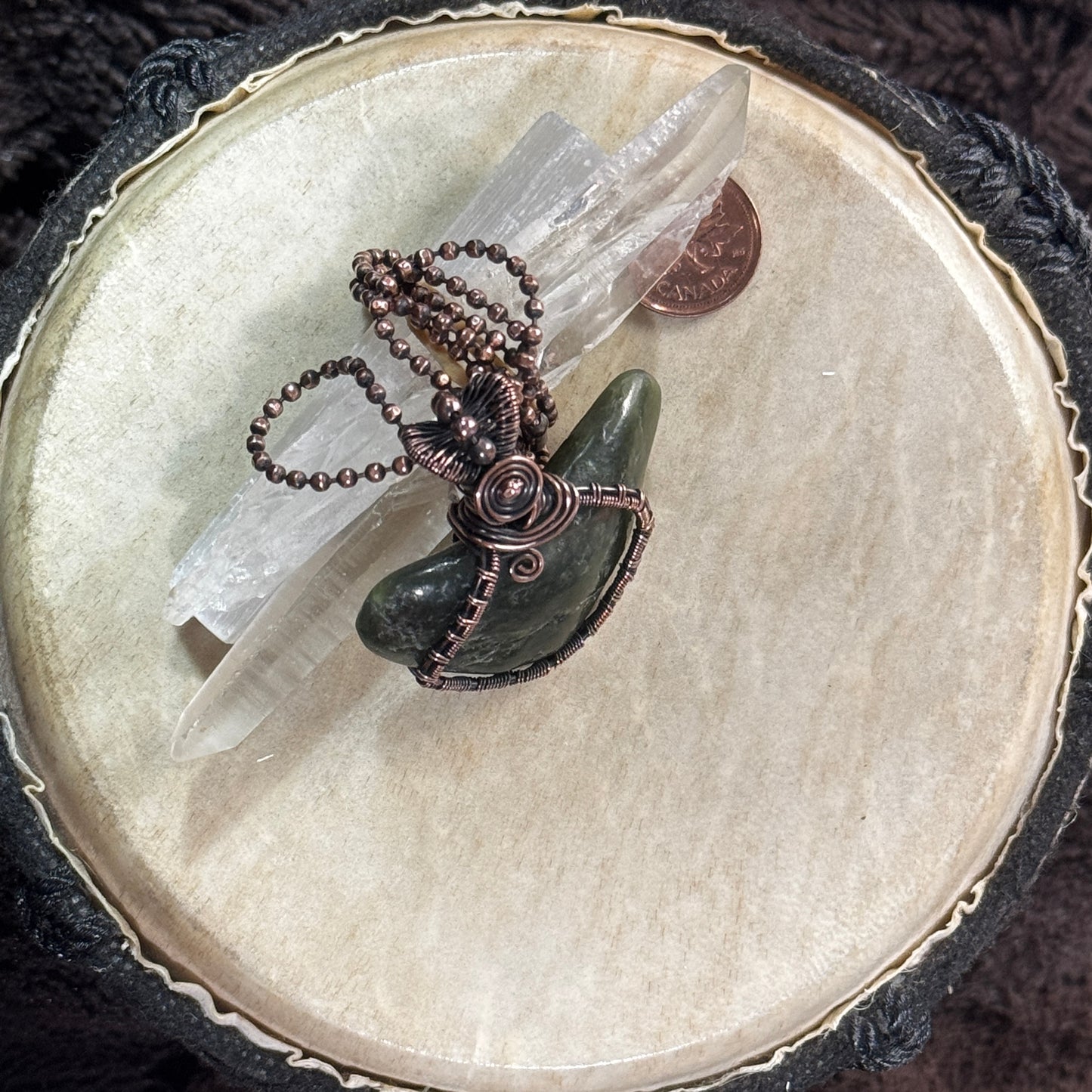 Handmade BC jade pendant in patinated copper displayed with clear crystal points, showing the organic stone shape and detailed wirework.