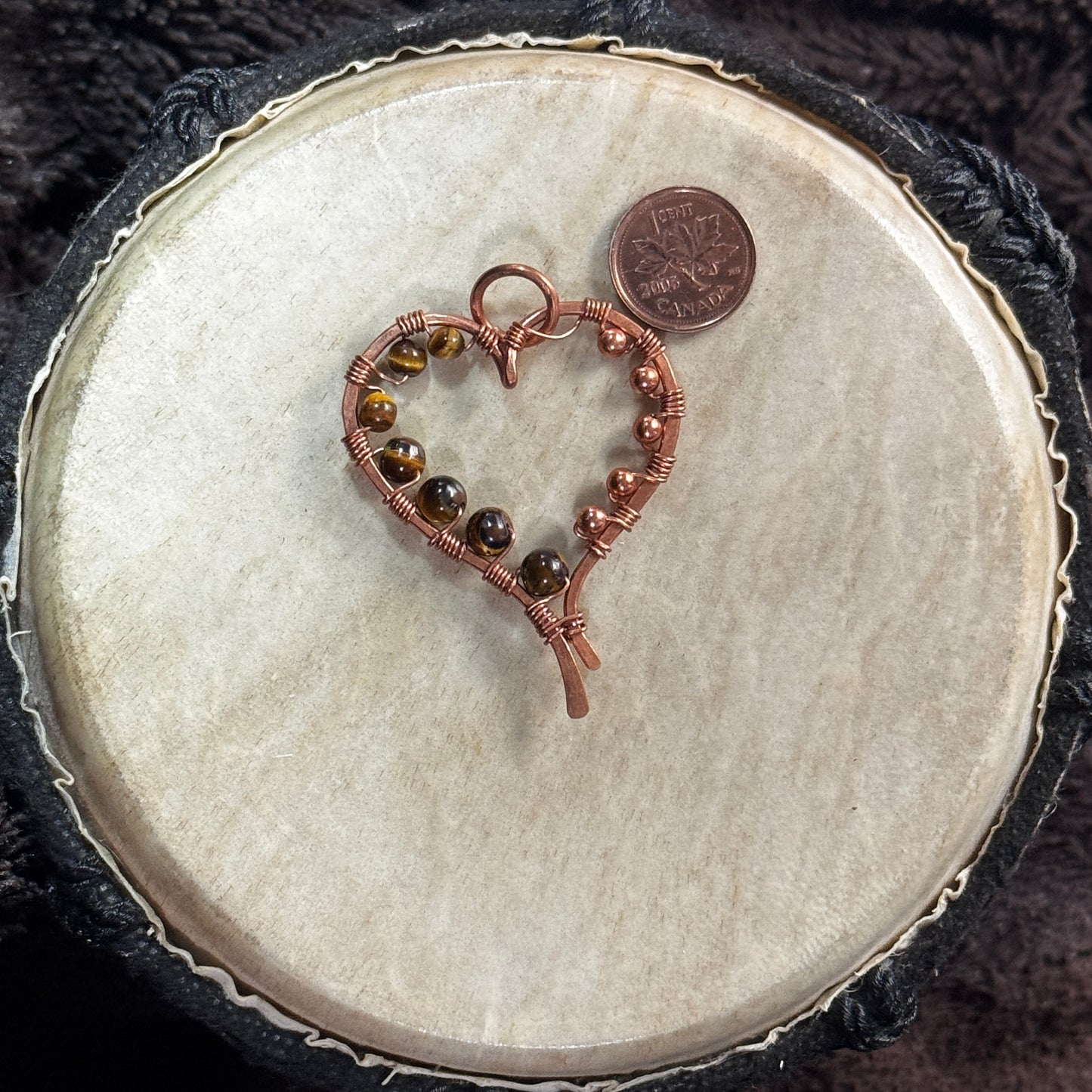 Reverse view of a handcrafted yellow tiger's eye heart pendant in raw copper with tiger's eye beads and copper bead accents.