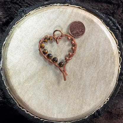 Reverse view of a handcrafted yellow tiger's eye heart pendant in raw copper with tiger's eye beads and copper bead accents.