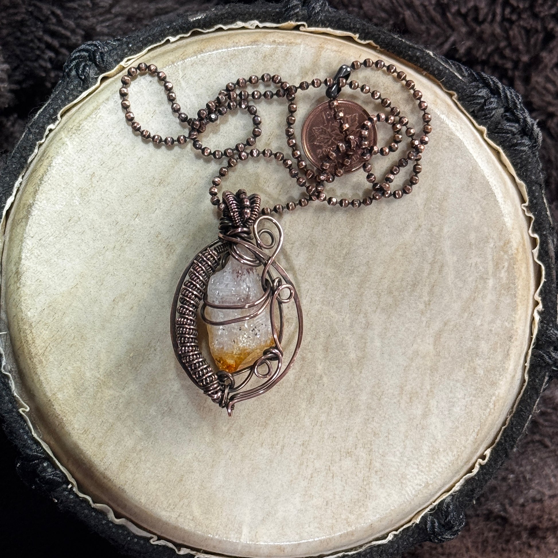 Raw citrine point necklace held inside hammered, patinated copper scrollwork with a woven side frame and 20-inch faceted copper ball chain.