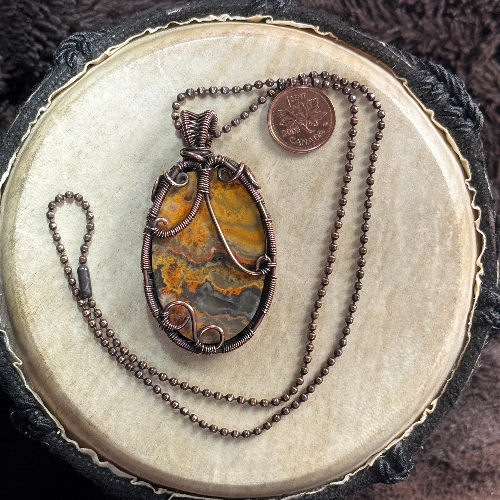 Reverse view of a Bumble Bee Jasper necklace showing the cabochon’s second patterned face and detailed patinated copper support wirework.