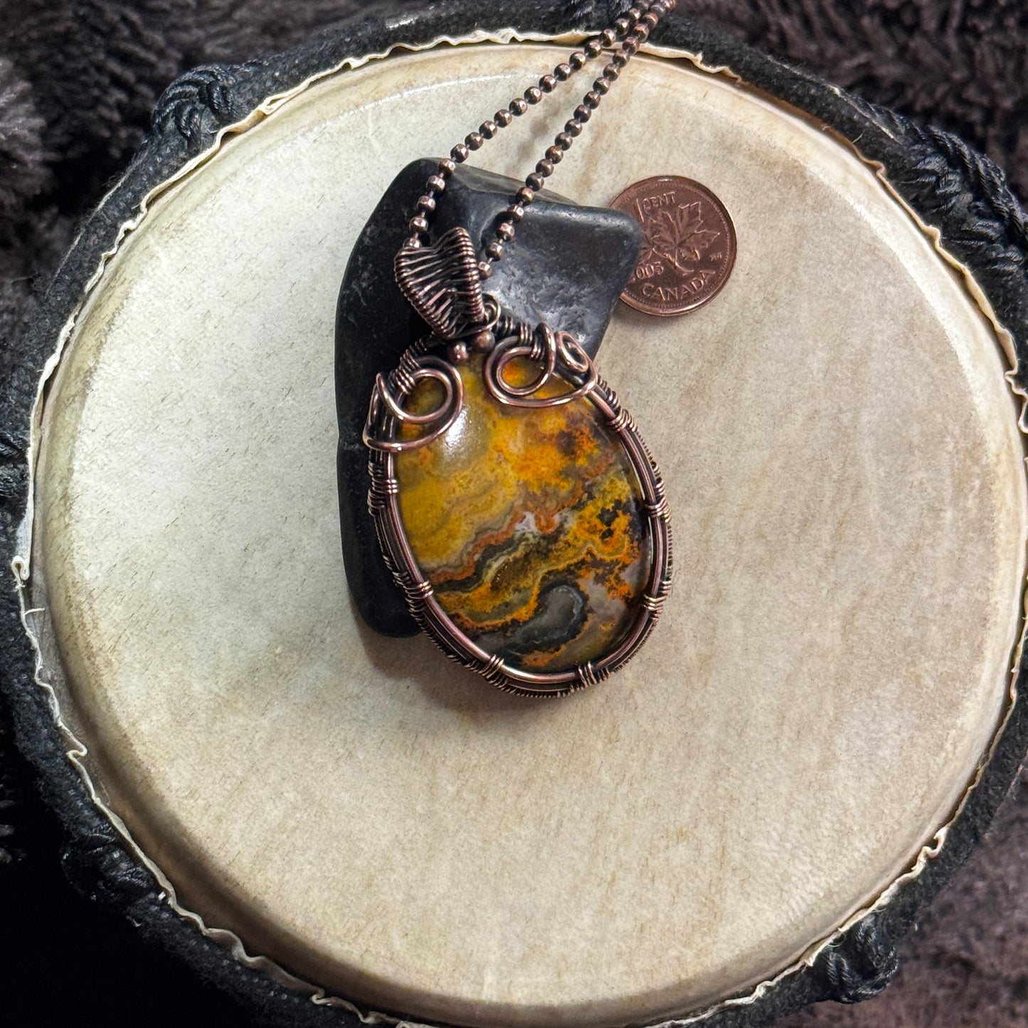 Bumble Bee Jasper statement necklace styled over black shungite, highlighting its molten yellow patterning and sculptural patinated copper wrap.