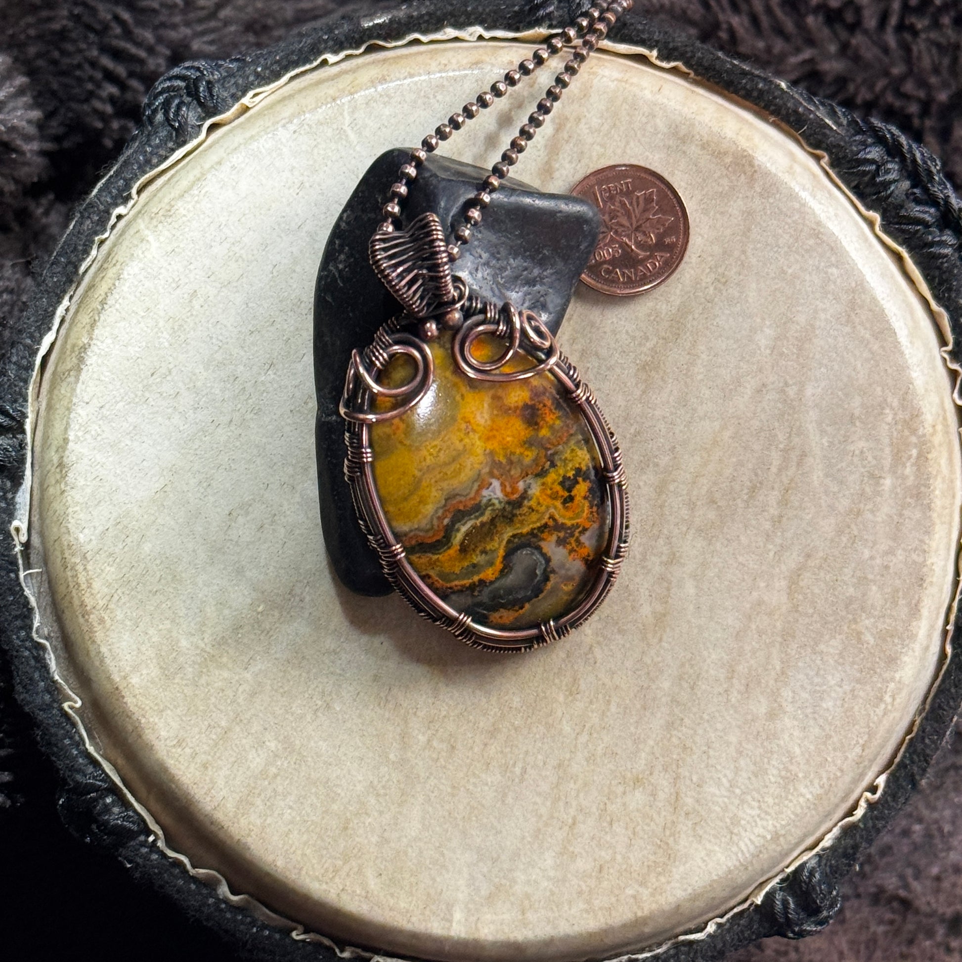 Bumble Bee Jasper statement necklace styled over black shungite, highlighting its molten yellow patterning and sculptural patinated copper wrap.
