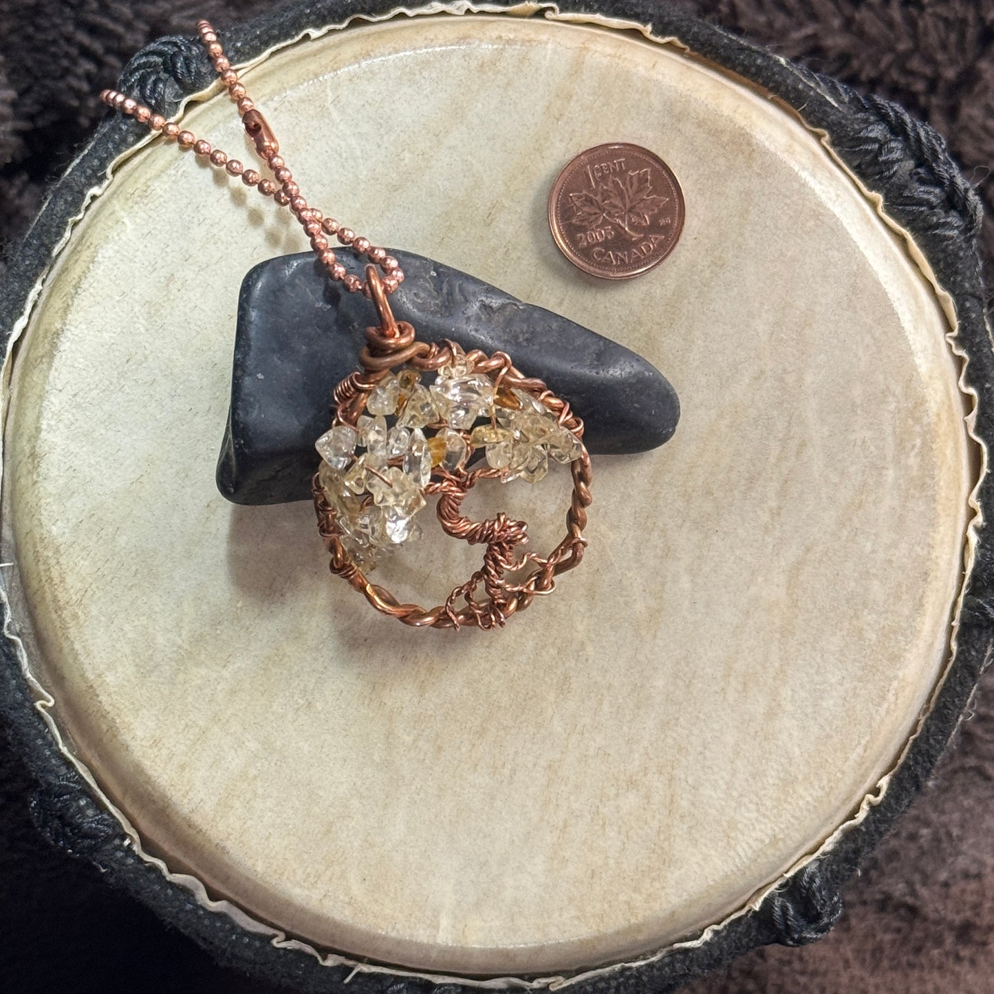 Raw copper and citrine teardrop Tree of Life necklace styled over black shungite with a faceted copper ball chain and penny shown for scale.