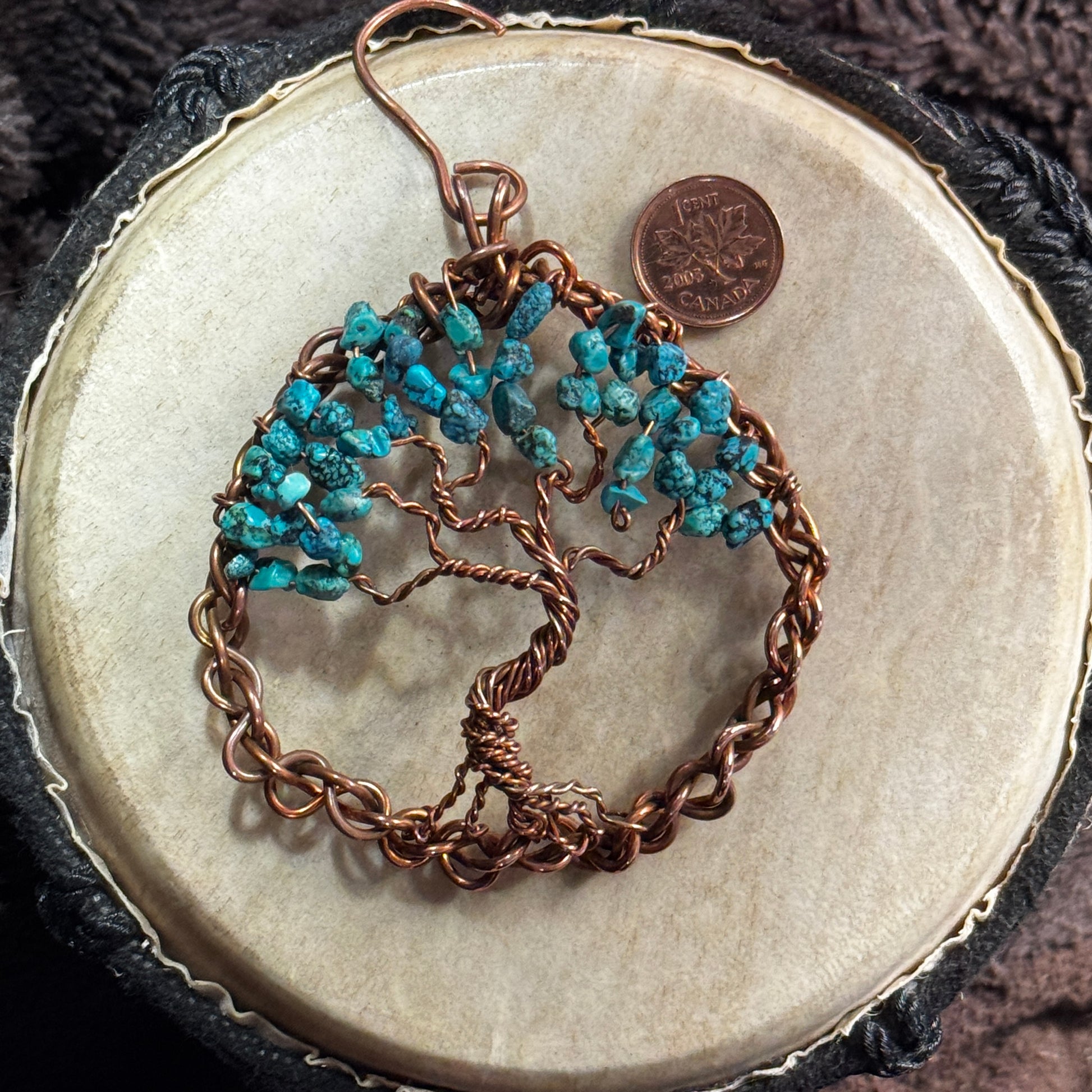 Full view of a three-inch turquoise Tree of Life formed inside a woven reclaimed copper circle, with a Canadian penny providing scale.