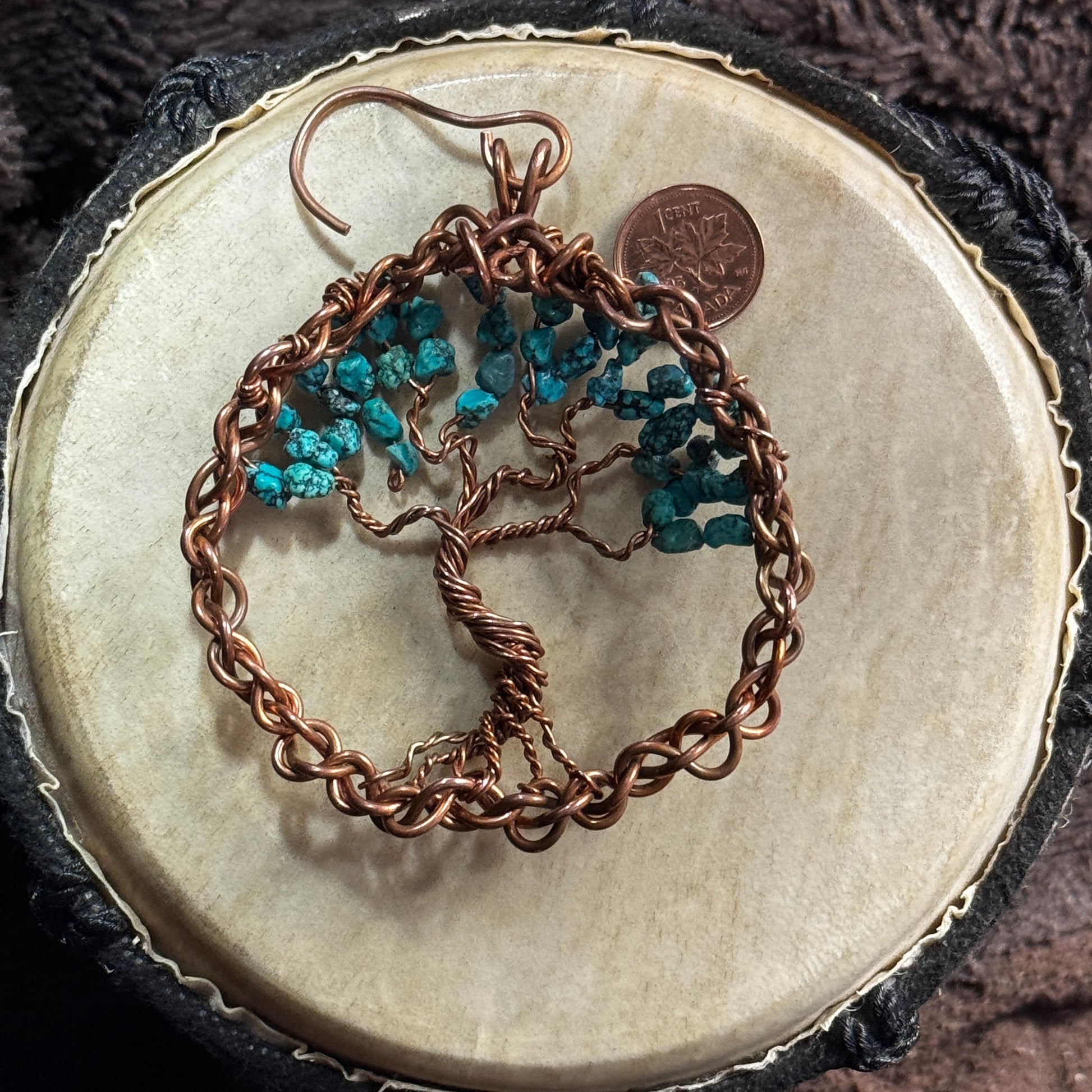 Reverse view of a turquoise Tree of Life suncatcher showing its hand-twisted copper trunk, spreading branches, woven frame and hanging hook.