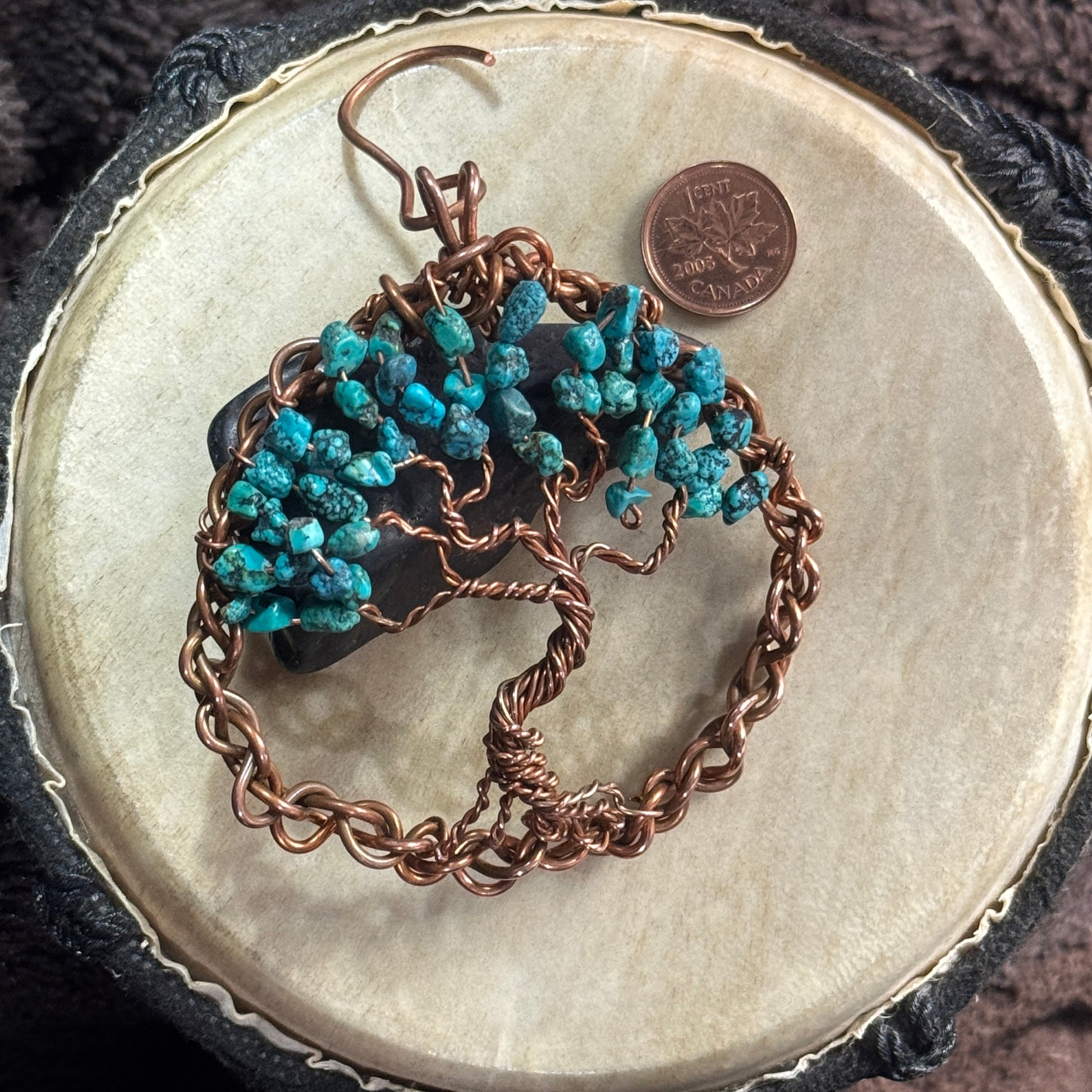 Three-inch reclaimed copper Tree of Life suncatcher with turquoise chip leaves, styled over black shungite with a Canadian penny for scale.