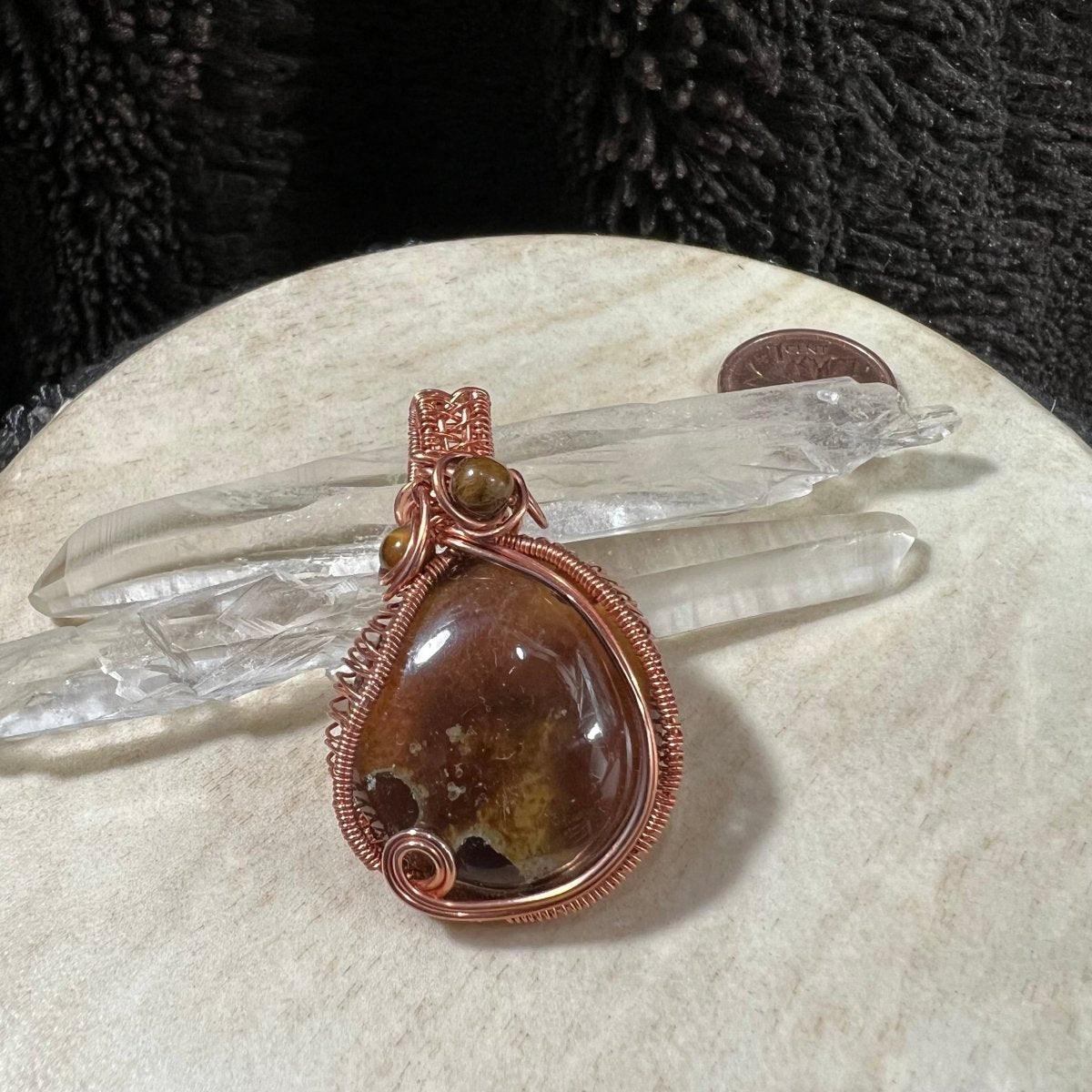 Amber pendant with golden and caramel tones wrapped in copper wire