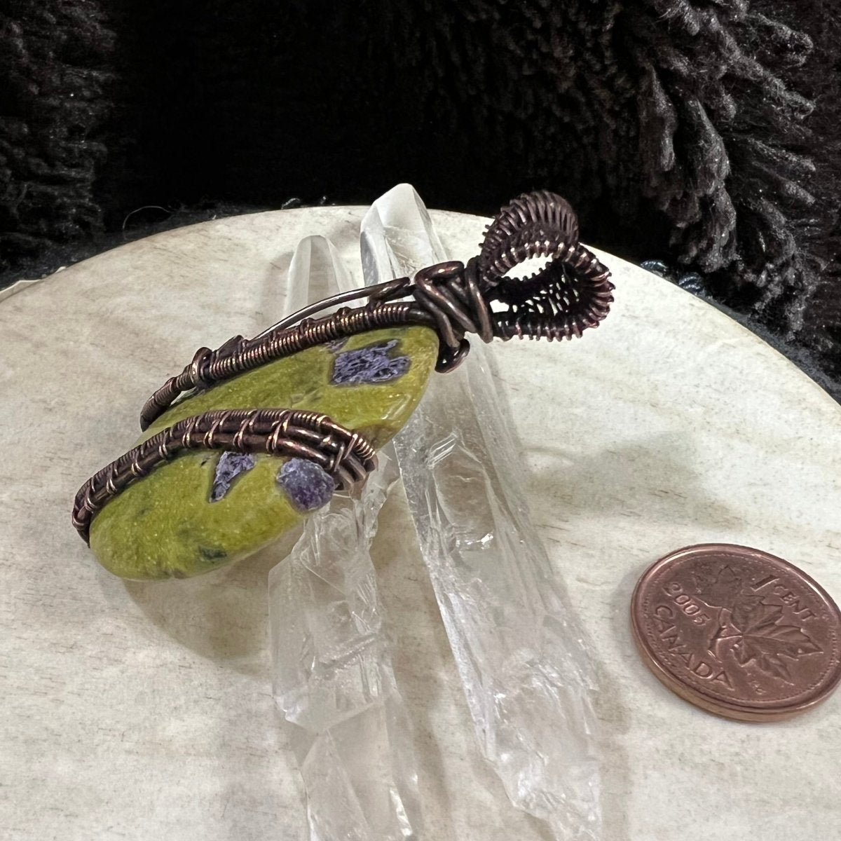 Side view of copper-wrapped Atlantisite pendant highlighting structural wire bands and handcrafted detail