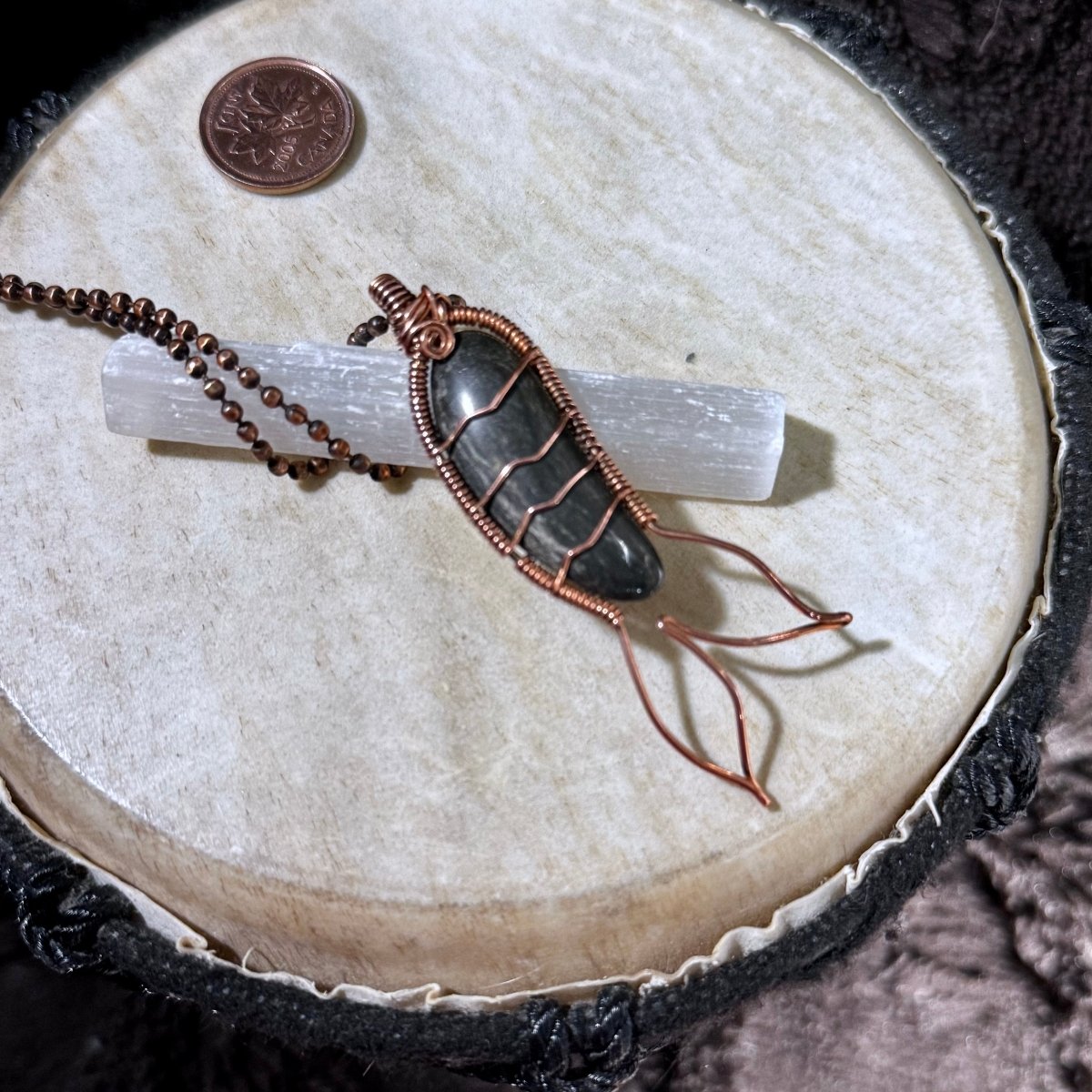 Profile view highlighting the polished black agate cabochon, reclaimed copper wire wrapping and flowing Mermaid Tail design.