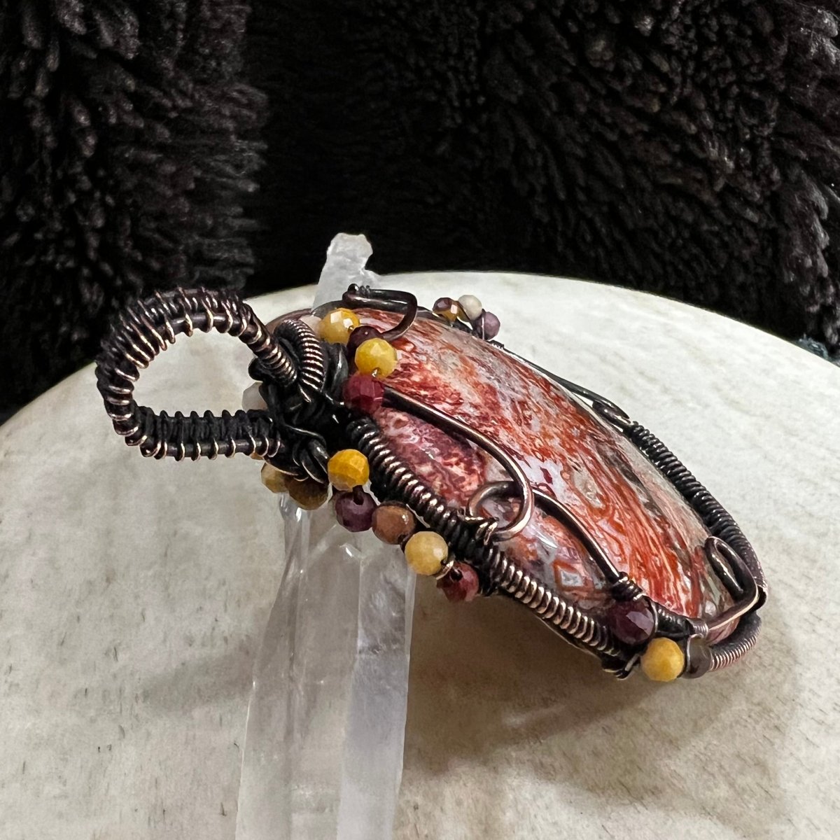 top down view of copper wire wrapped crazy lace agate pendant accented with mookaite jasper beads
