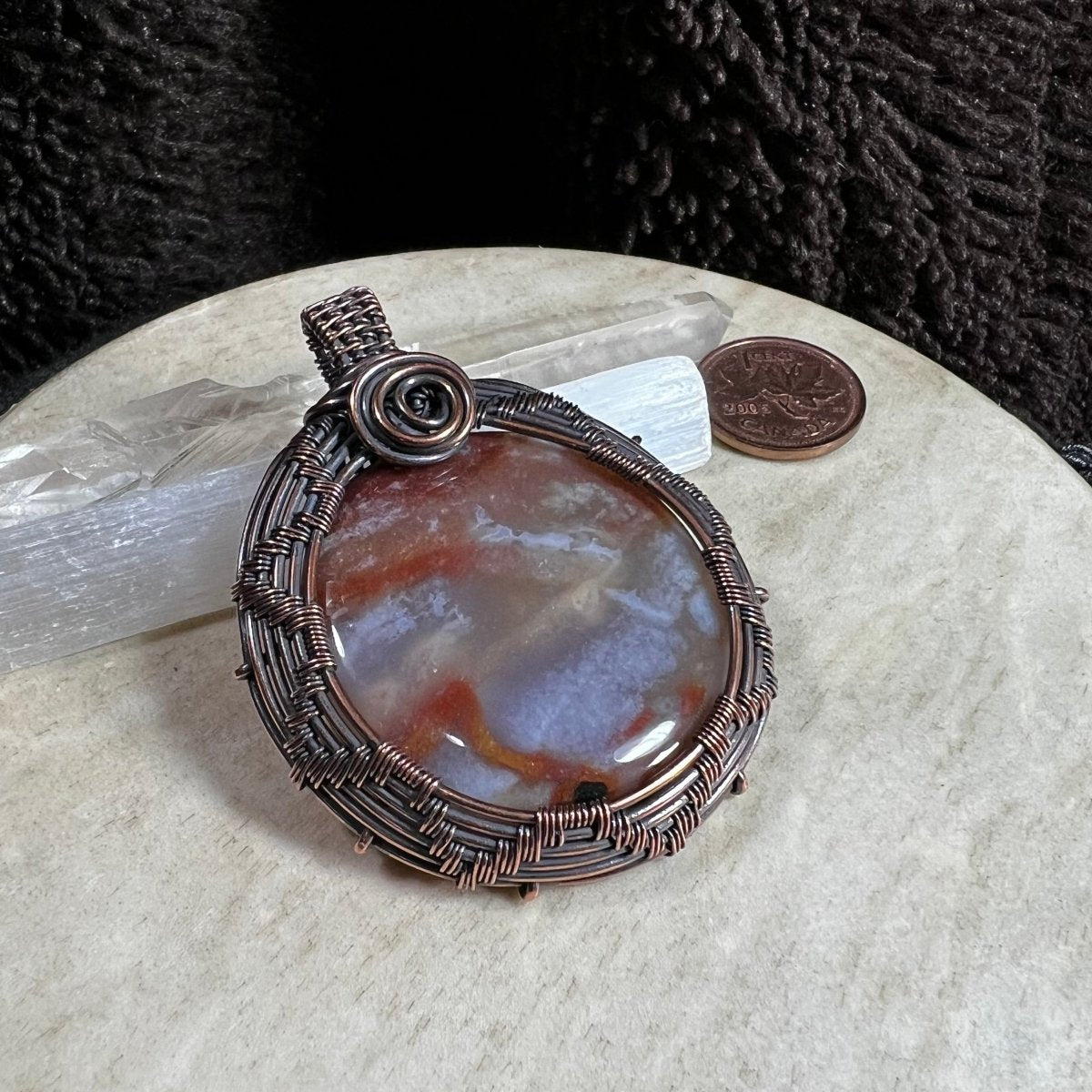 Flower agate pendant displayed with selenite crystals for contrast and scale