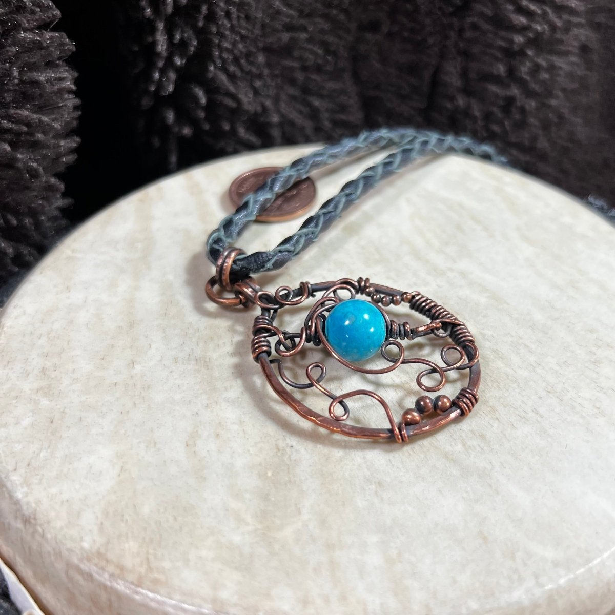 Handcrafted copper swirl pendant featuring dyed magnesite bead on braided cord necklace