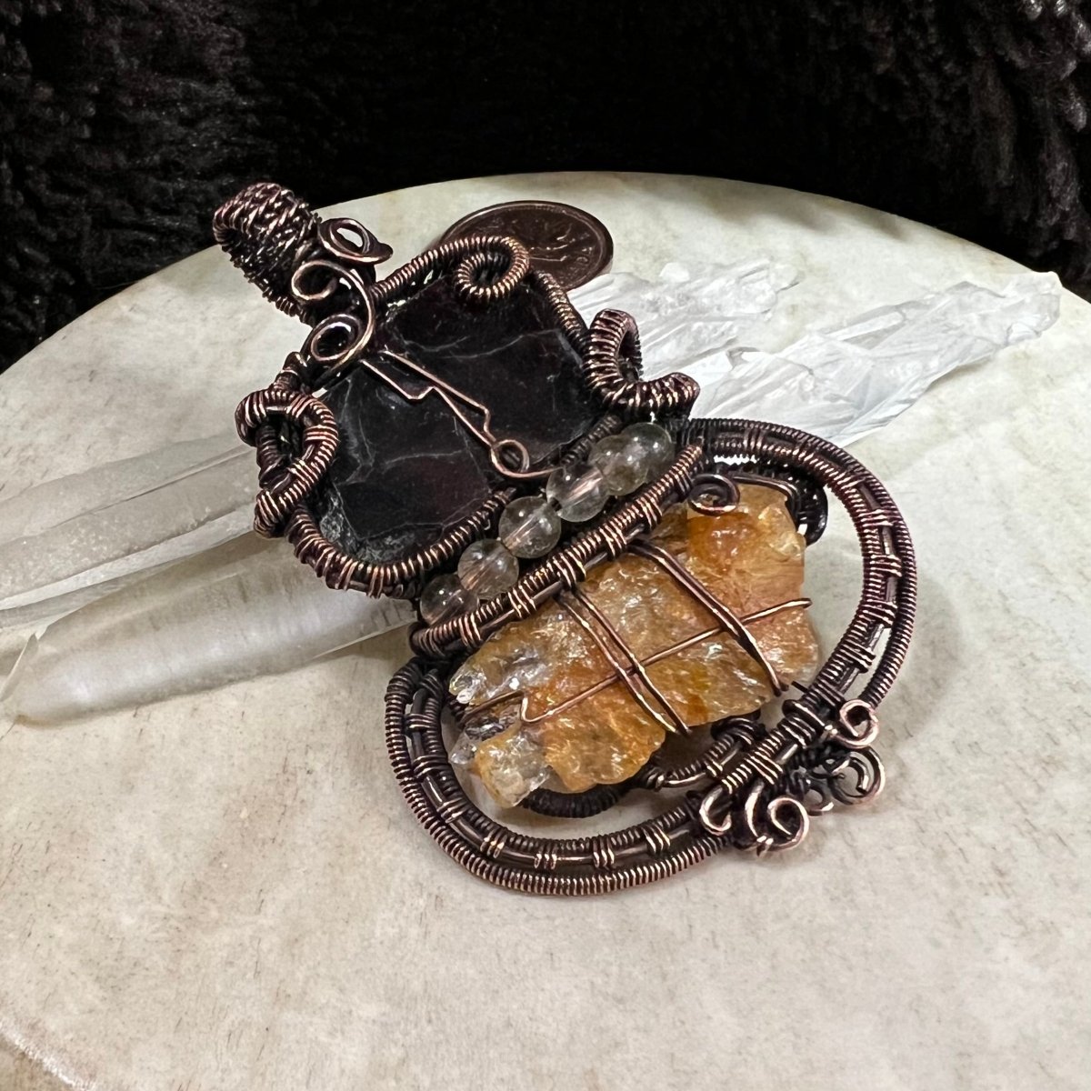 Garnet slice pendant wrapped in patinated copper with raw sunstone and citrine accents, rich dark and golden contrast