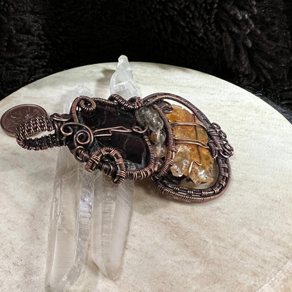 Side angle of copper pendant highlighting layered wirework, patina finish, and raw stone textures