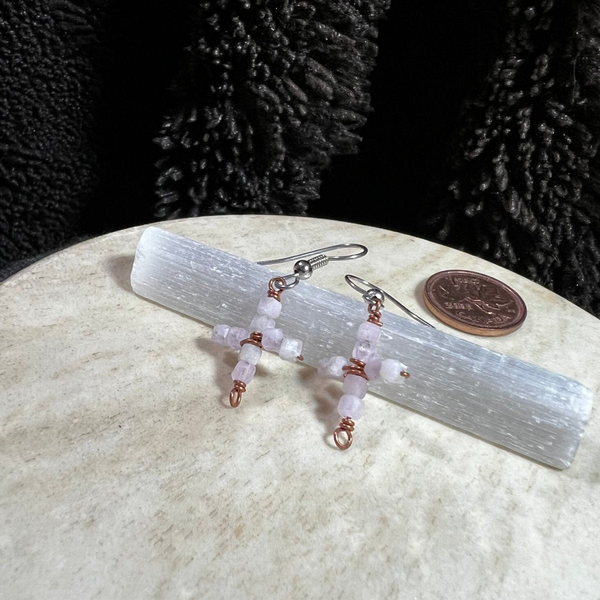 Pair of beaded earrings on a crystal with a coin for scale