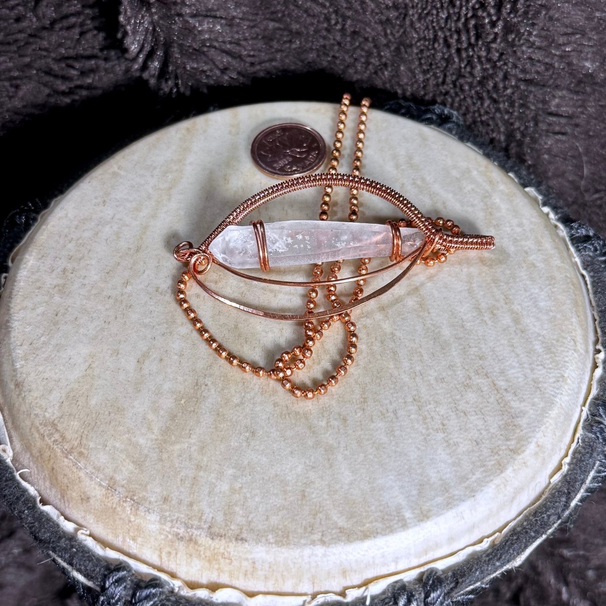 Back view of the Lemurian Quartz point pendant showing its open copper framework, handwoven lower curve and 20-inch faceted copper ball chain.