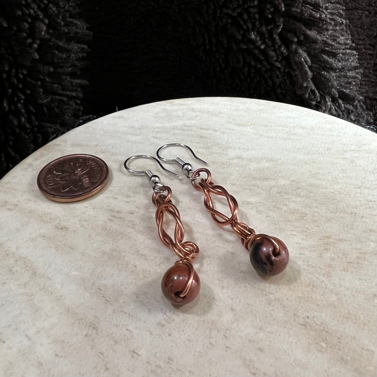 mahogany obsidian Sailor's Knot earrings with copper wire wrapping and surgical steel earwires, handmade brown and black stone dangle earrings on neutral background