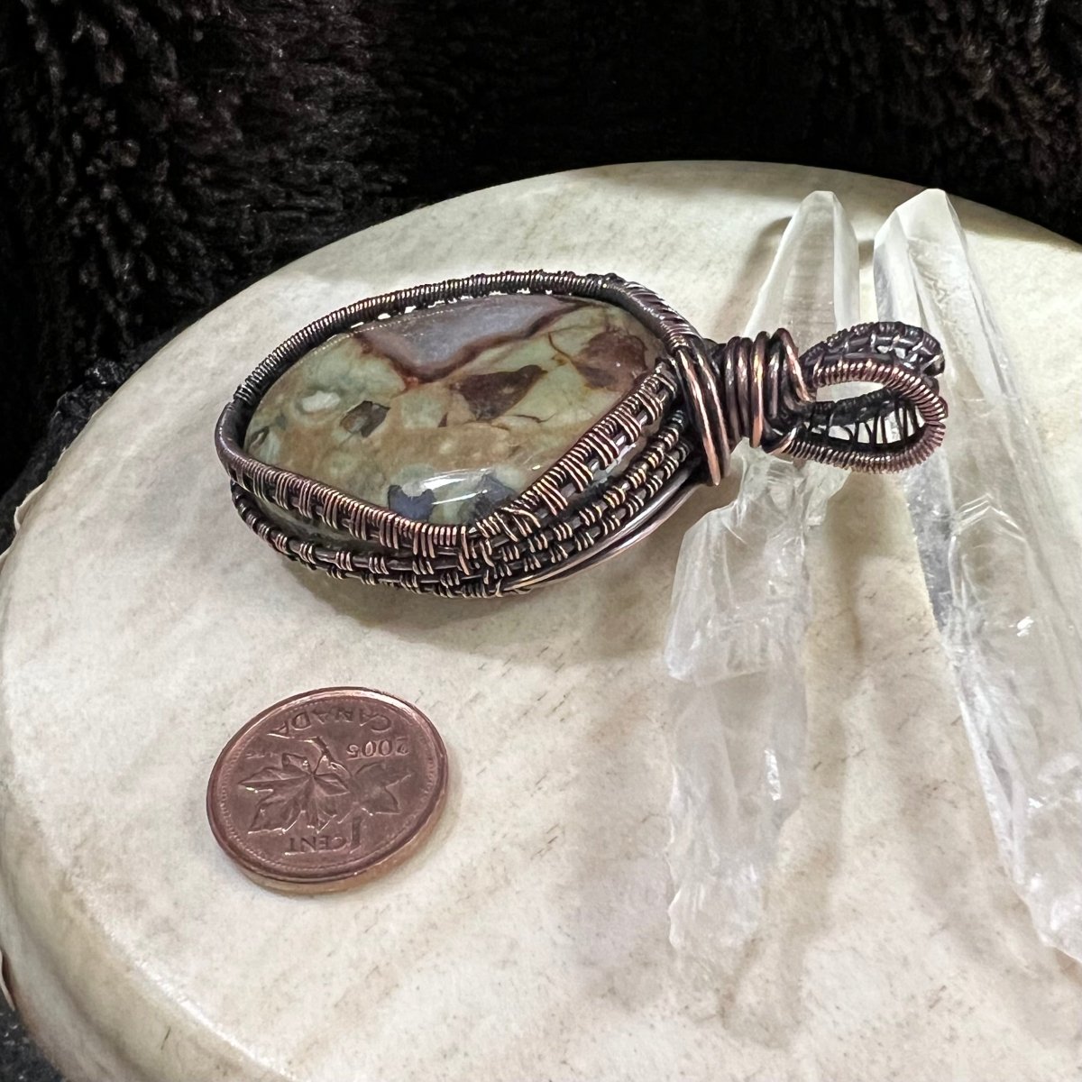 Side profile of copper-wrapped jasper pendant highlighting layered wirework