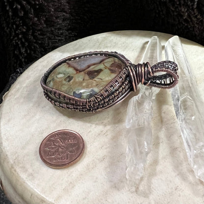 Side profile of copper-wrapped jasper pendant highlighting layered wirework