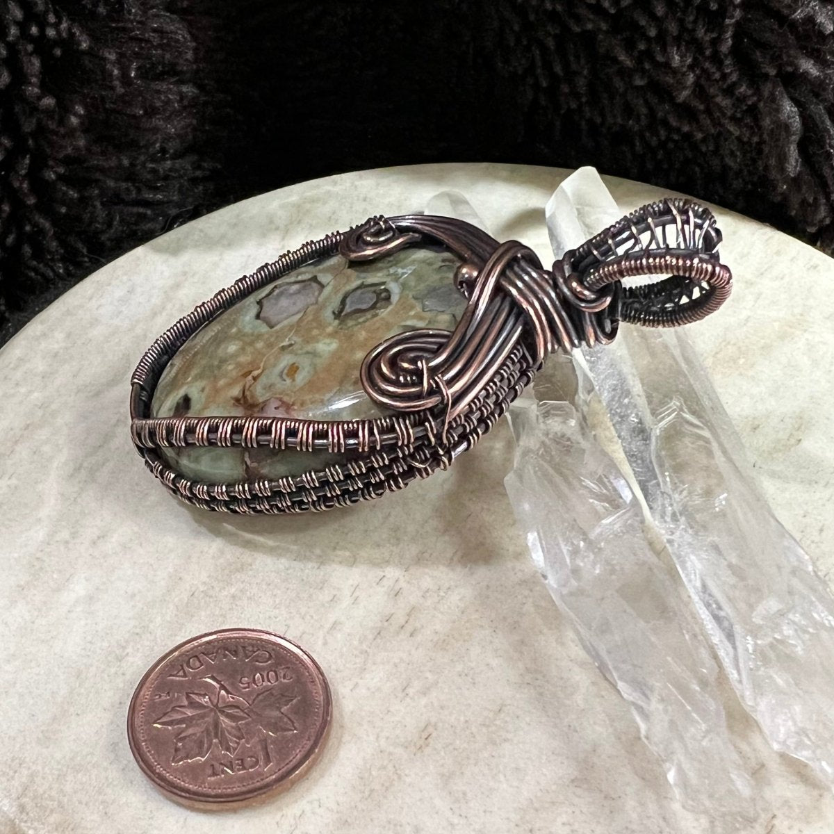Ocean jasper pendant with soft green and cream orb patterns wrapped in patinated copper