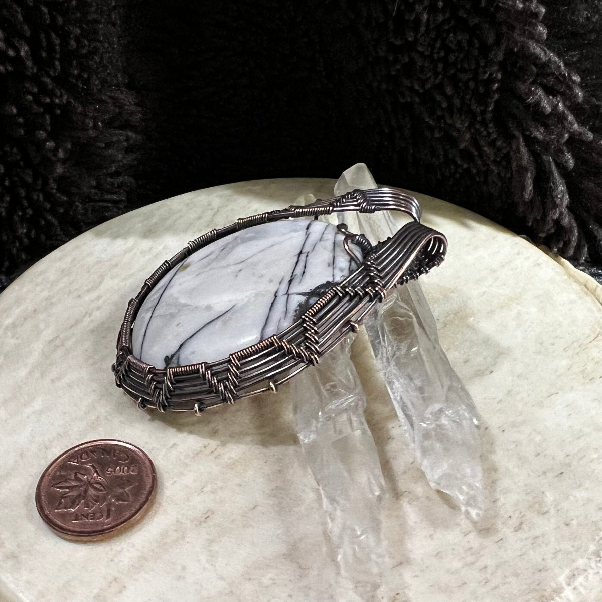Picasso jasper pendant displayed with quartz crystals and Canadian penny  for scale and neutral contrast