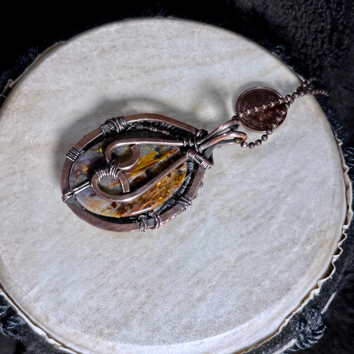 Back view of the Pietersite cabochon necklace showing the secure hand-built copper framework, decorative bail and faceted copper ball chain.