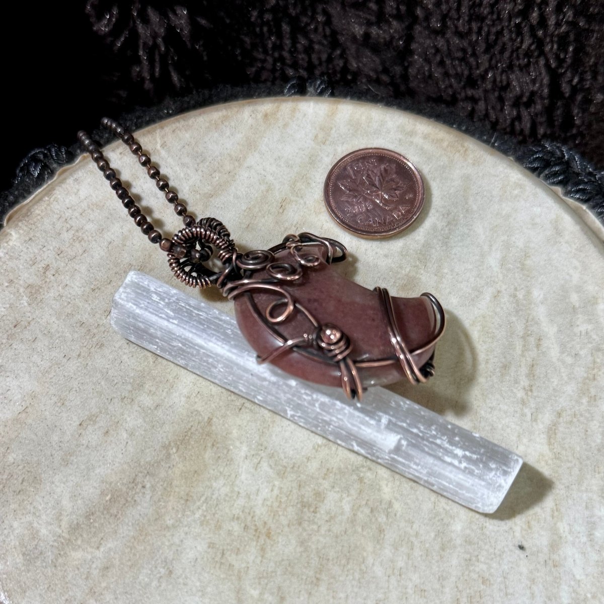 Side detail of the Purple Aventurine crescent moon pendant showing its polished surface, copper spiral accents and secure wire setting.