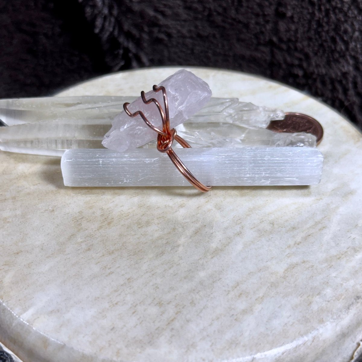 Side view of a size 8.5 raw rose quartz statement ring showing the crystal’s substantial profile and secure copper setting.
