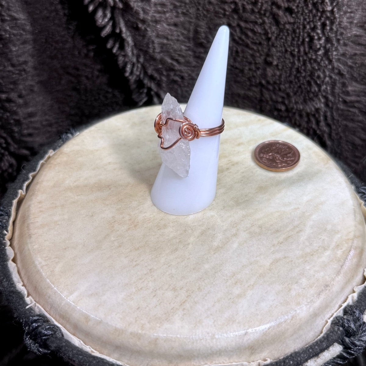 Side view of a size 6 raw rose quartz ring showing its natural crystal edges, copper spiral and triple-wire band.