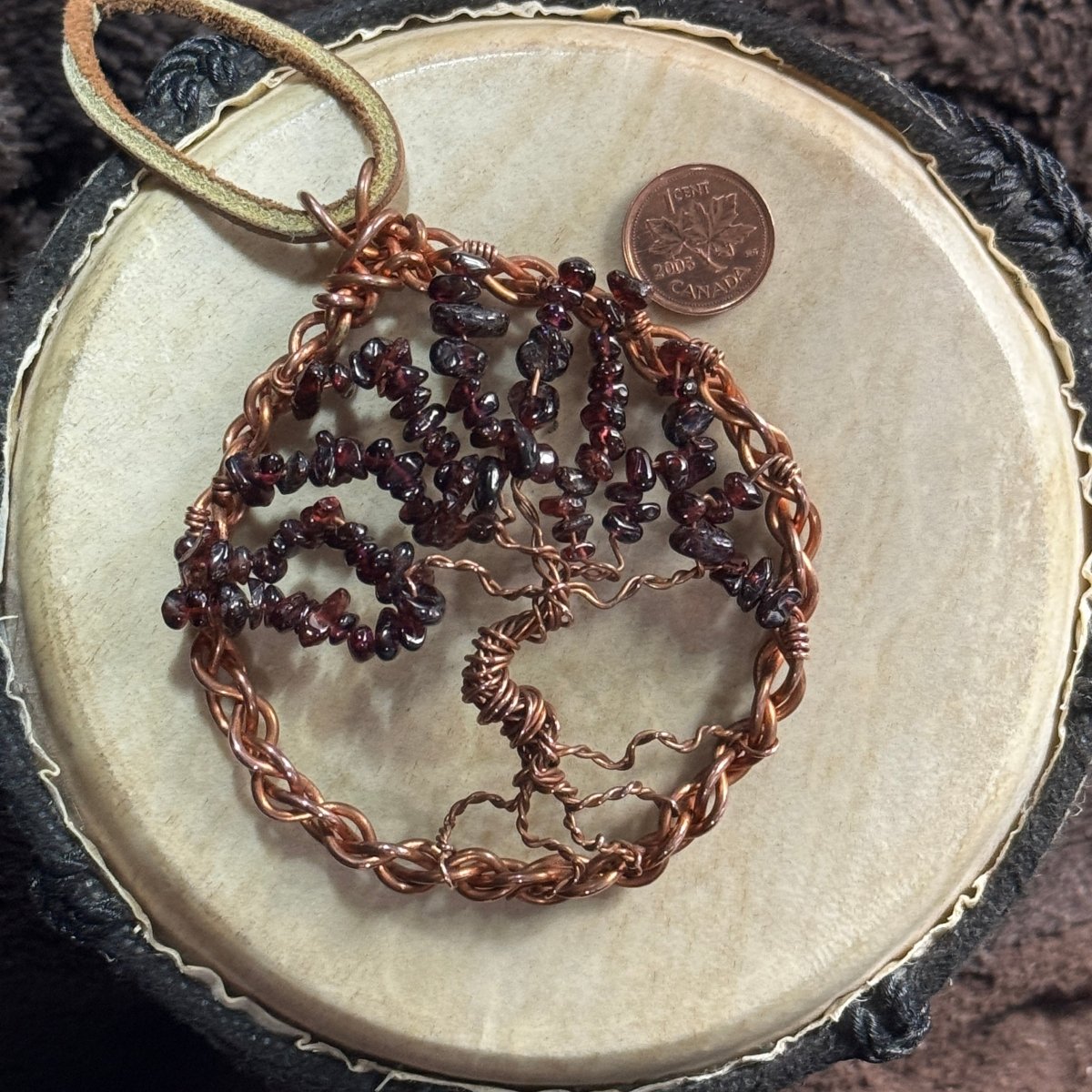 Three-inch reclaimed copper Tree of Life suncatcher with deep red garnet chip branches, leather hanger and a Canadian penny shown for scale.