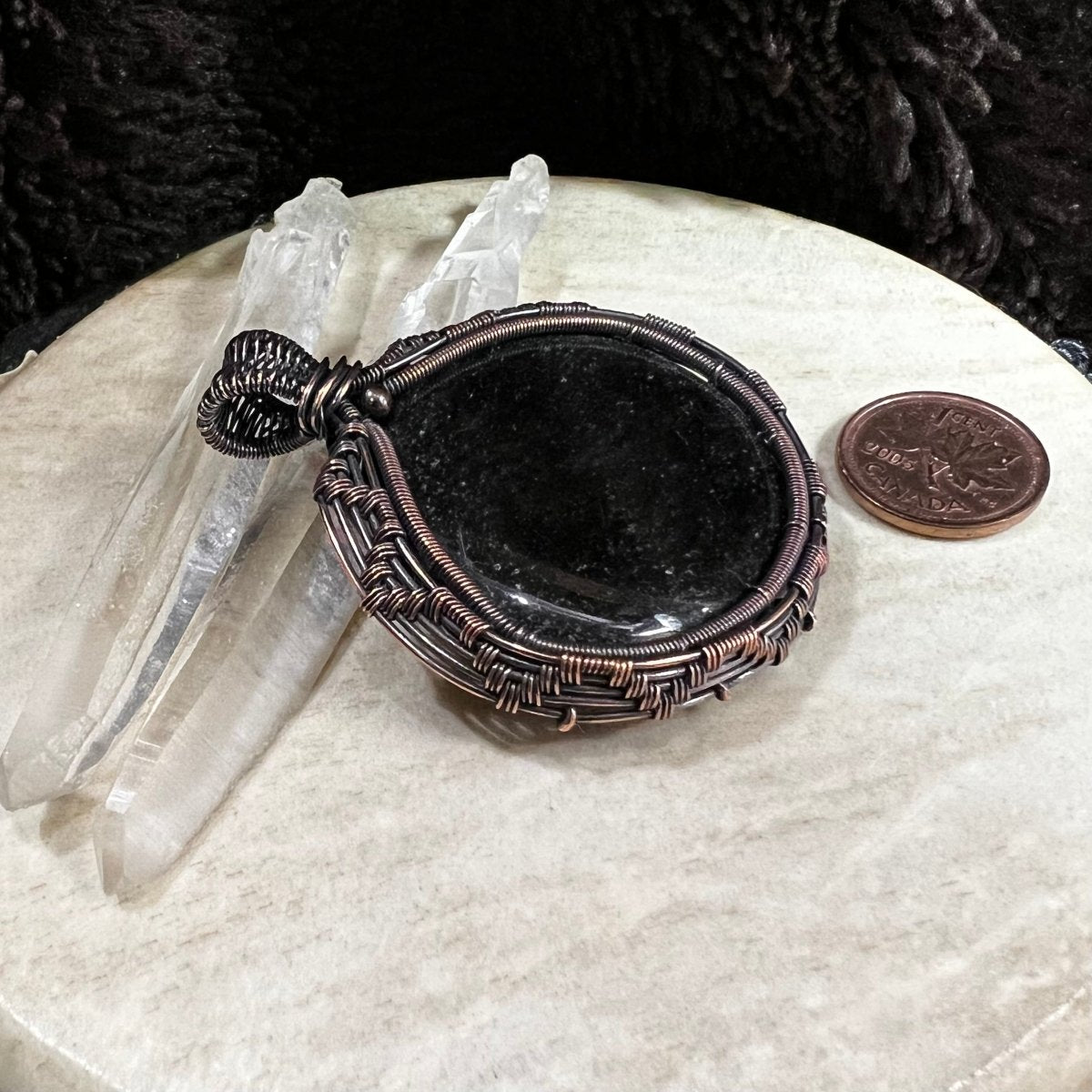Silver sheen obsidian pendant wrapped in patinated copper with deep black polished surface and subtle reflective glow