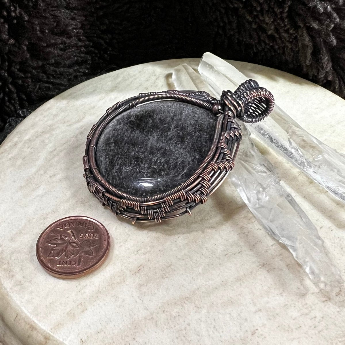 Alternate lighting view of silver sheen obsidian pendant revealing soft silver shimmer beneath black surface