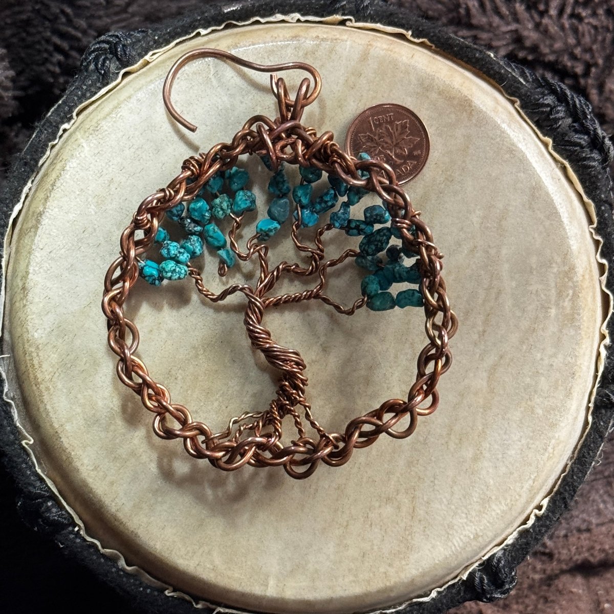 Reverse view of a turquoise Tree of Life suncatcher showing its hand-twisted copper trunk, spreading branches, woven frame and hanging hook.