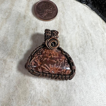 Close-up of handmade Starburst Jasper copper pendant highlighting natural sunburst mineral patterns.