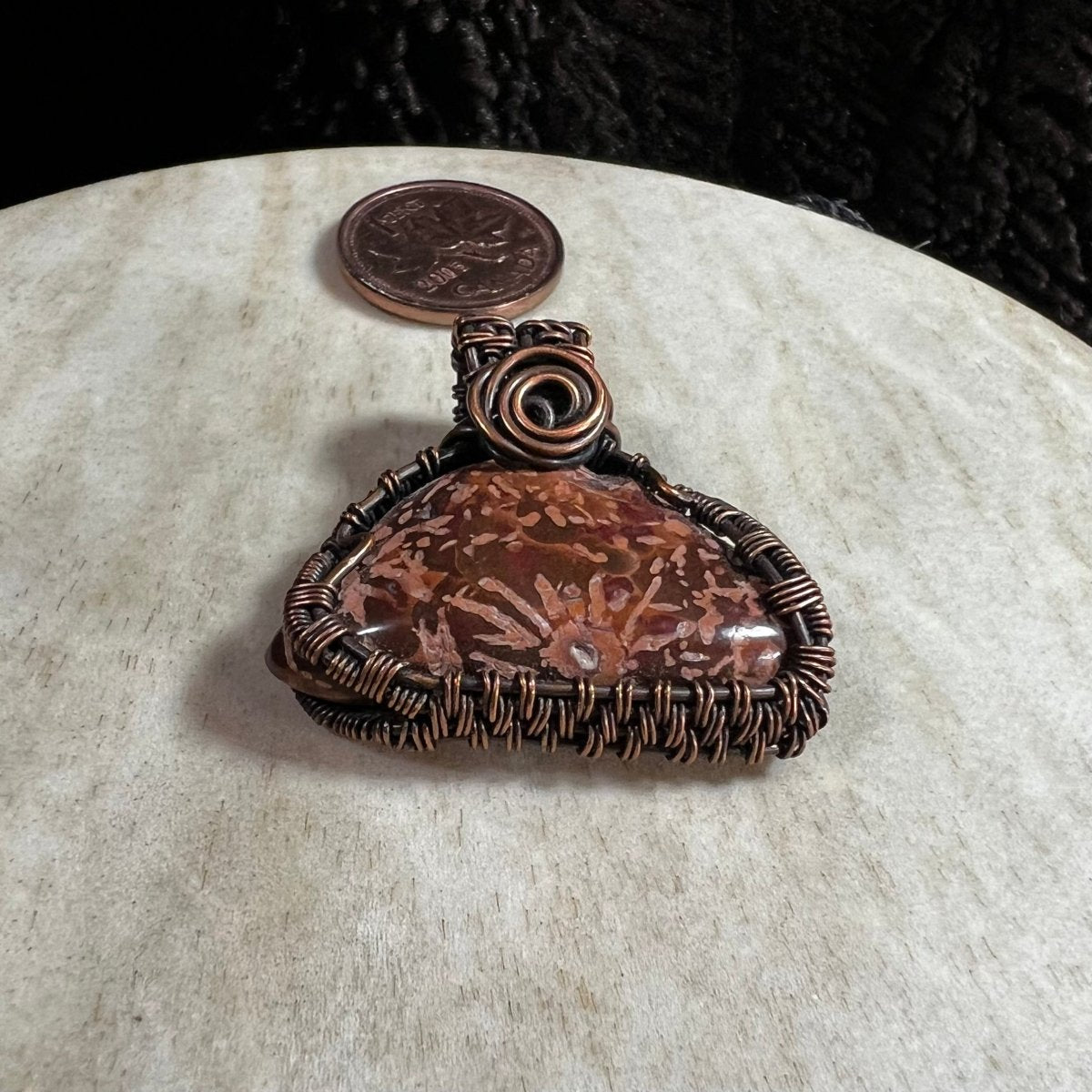 Close-up of handmade Starburst Jasper copper pendant highlighting natural sunburst mineral patterns.