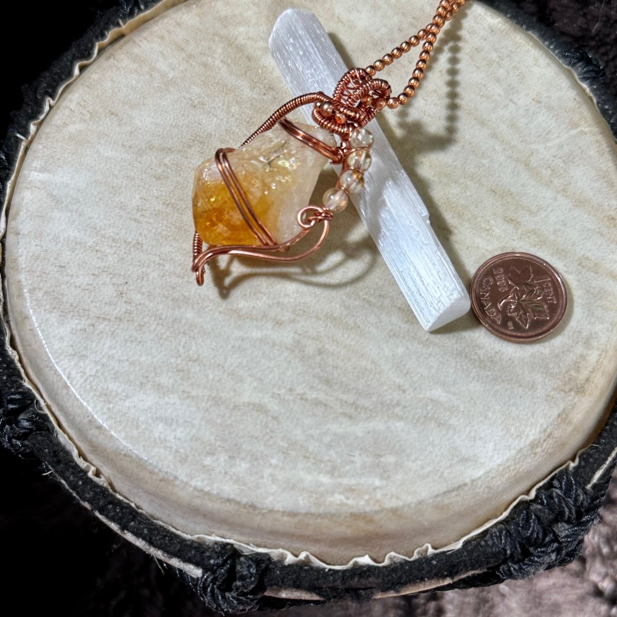 Front view of The Sunkeeper’s Secret necklace, featuring a raw golden citrine point, citrine beads and flowing reclaimed copper wirework on a 21-inch chain.