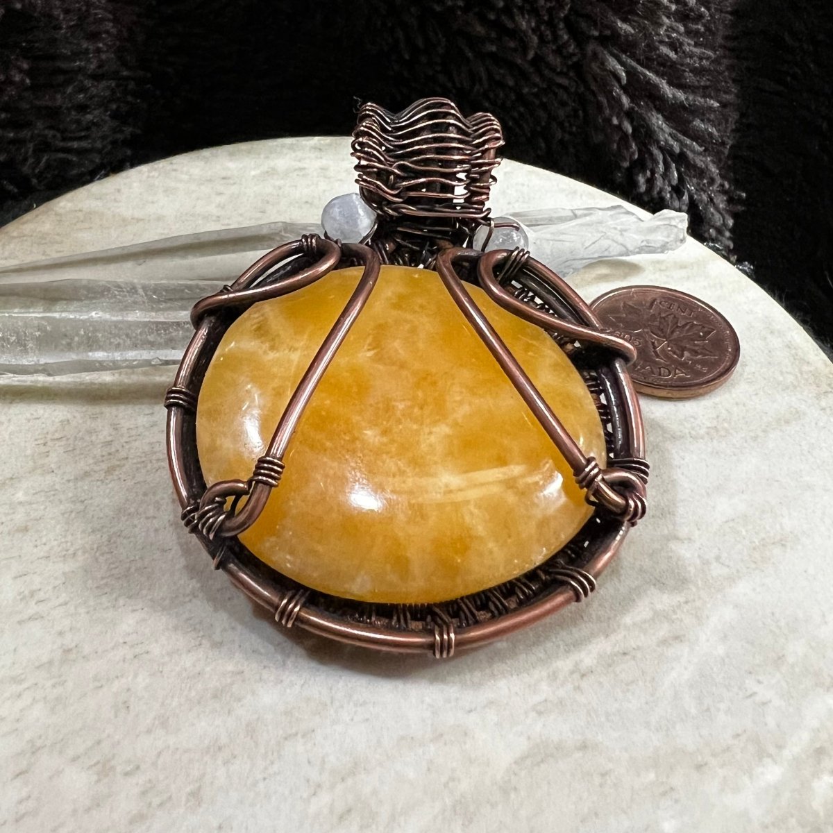 Back view of copper-wrapped yellow calcite pendant showing secure handcrafted structure and finish