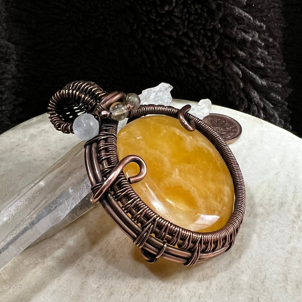 Yellow calcite pendant displayed with quartz points, showcasing size and natural colour variation
