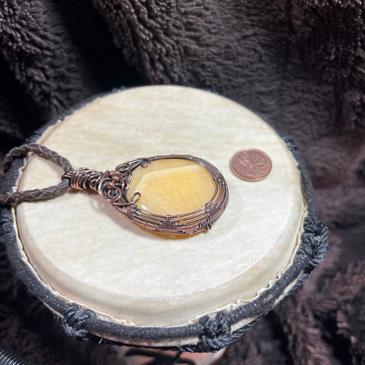 Necklace with a yellow stonependant on a round white stone with a dark textured background