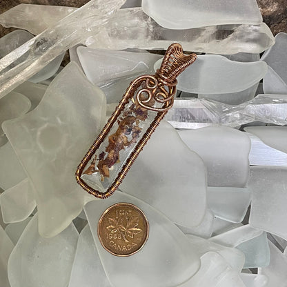 Close up of Rose in Resin Bar Pendant lying in white seaglass, with Canadian penny for scale